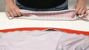 Das Tuch auf die Jacke legen und gleichmäßig bügeln. Wichtig ist, nicht zu lange zu bügeln, damit der Stoff nicht zu heiß wird. Lieber einmal mehr unter dem Tuch prüfen, ob das Bügeln ausgereicht hat und zusätzlich festdrücken. Das Bügeln dient zum besseren Fixieren vor dem Nähen.
