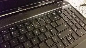 Verwende deine Fingernägel, um zwischen die Handauflage und die Tastatur zu gelangen, und heble die Tastatur heraus.